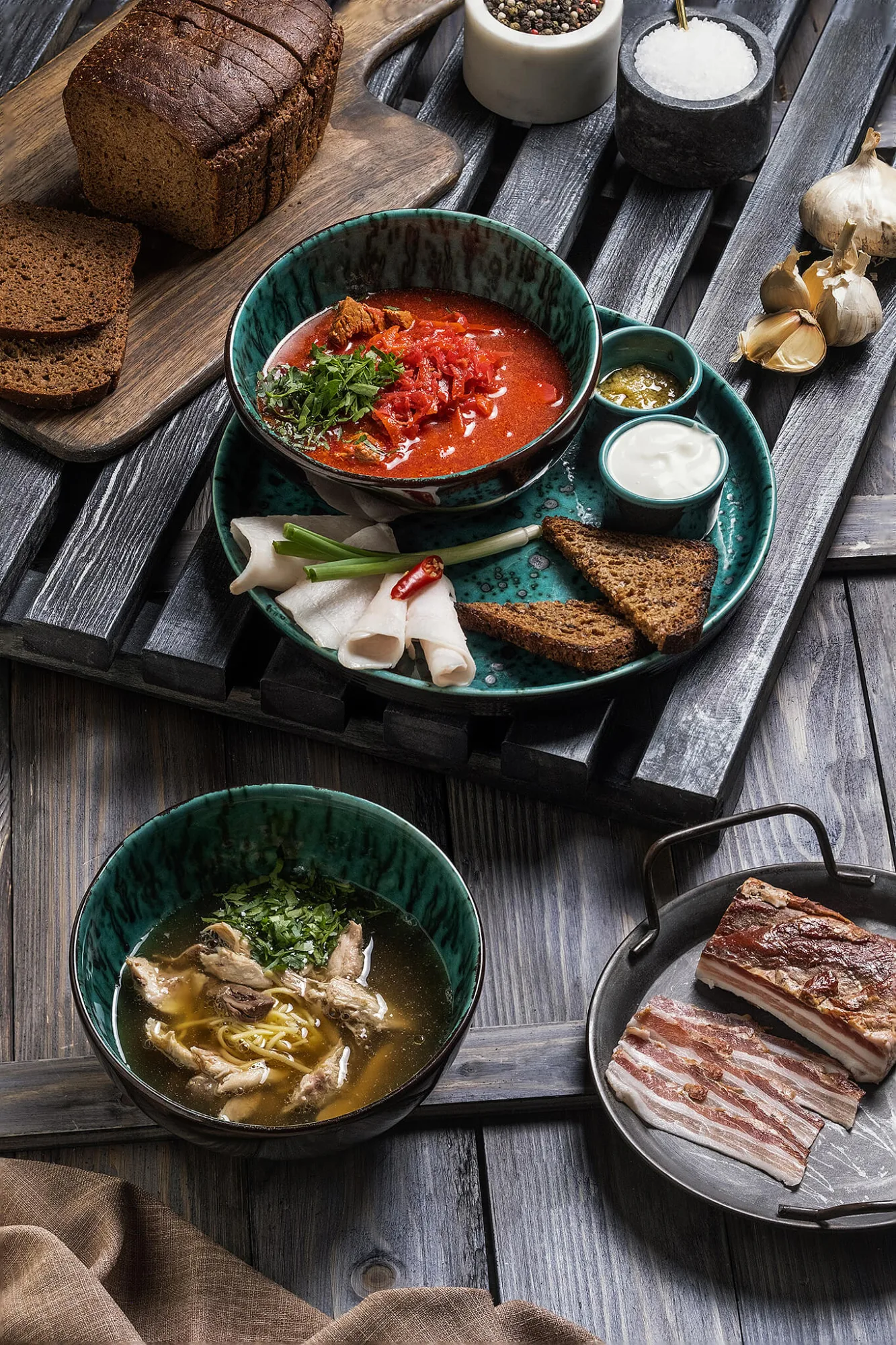 Ukrainian borscht with rye bread, salo and mushroom soup on rustic table, photo by Alex Slyadnev