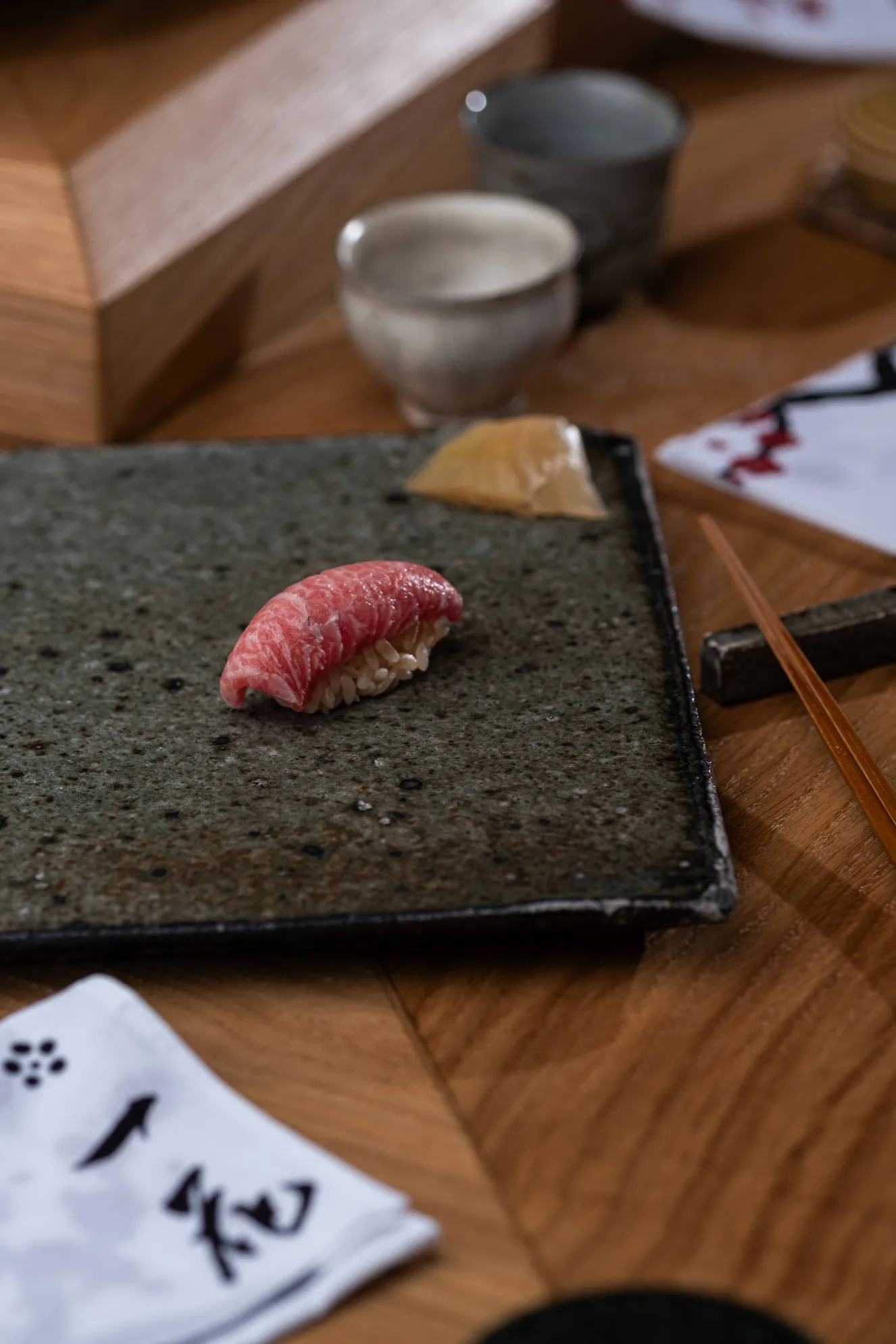 Otoro tuna nigiri with pickled ginger on a stone plate, photo by Alex Slyadnev