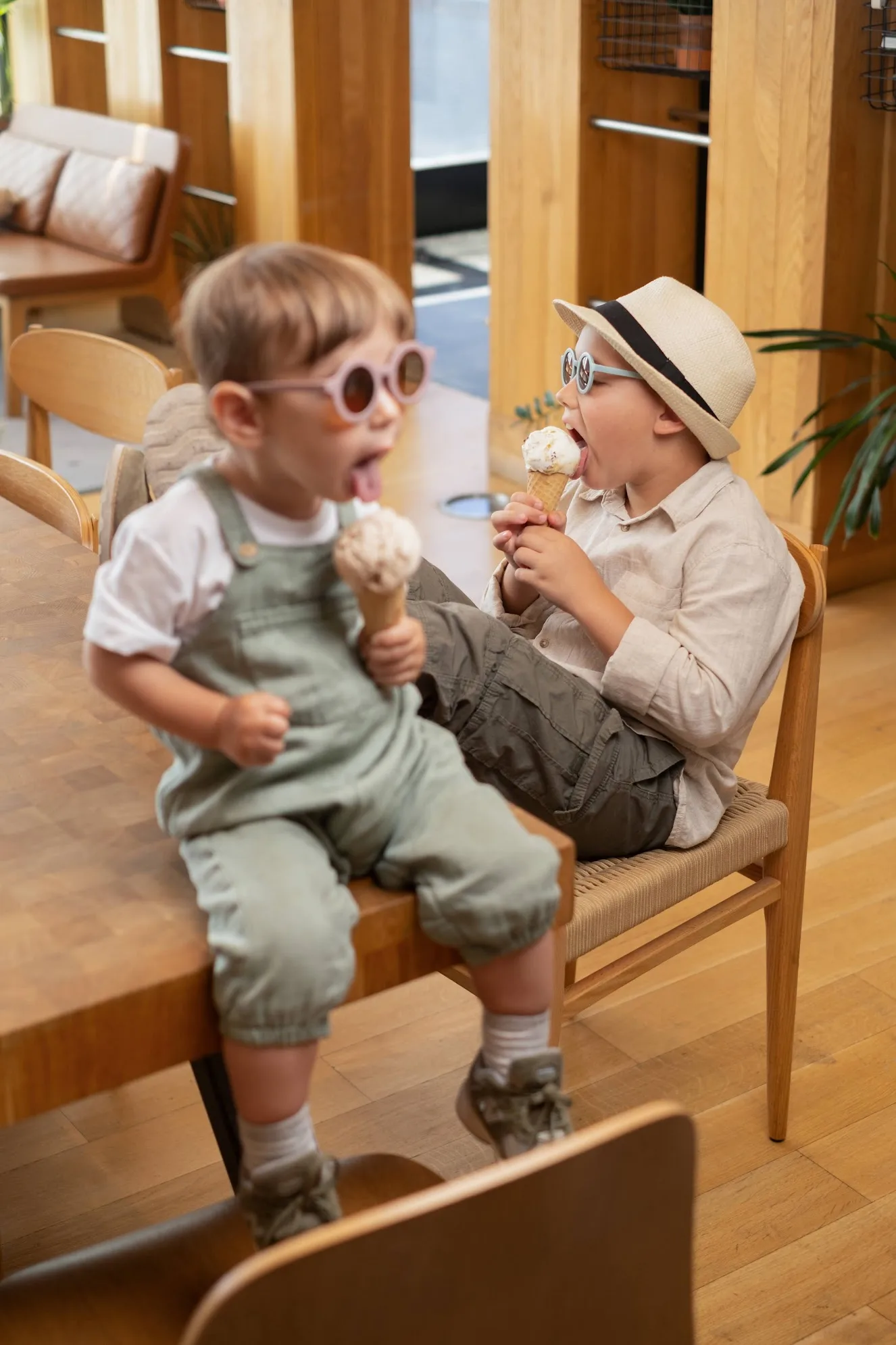 Two children eating ice cream cones in a cafe, photo by Alex Slyadnev