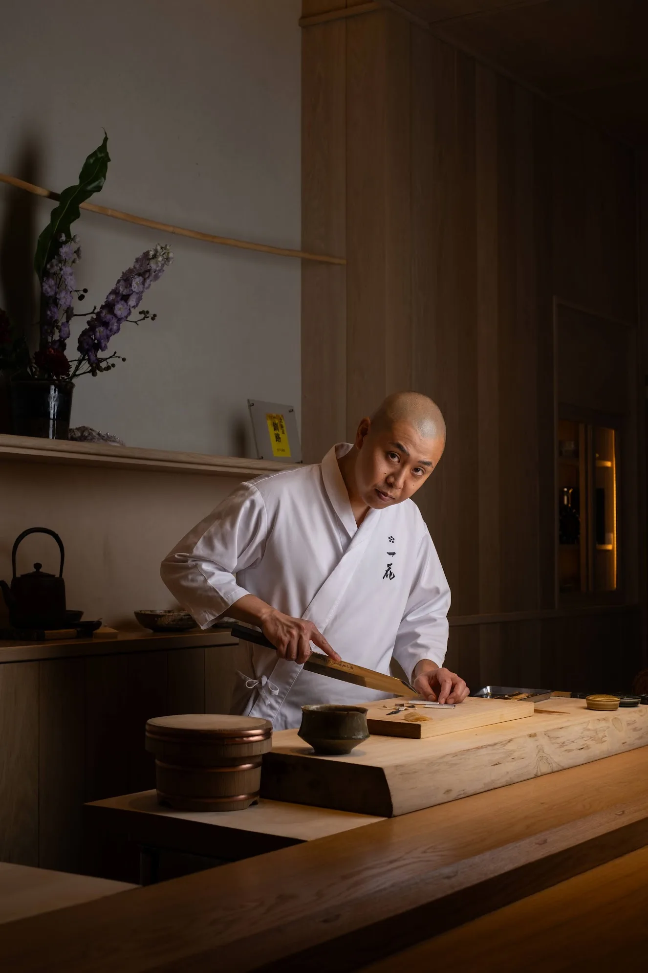 Japanese sushi chef at a wooden counter, photo by Alex Slyadnev