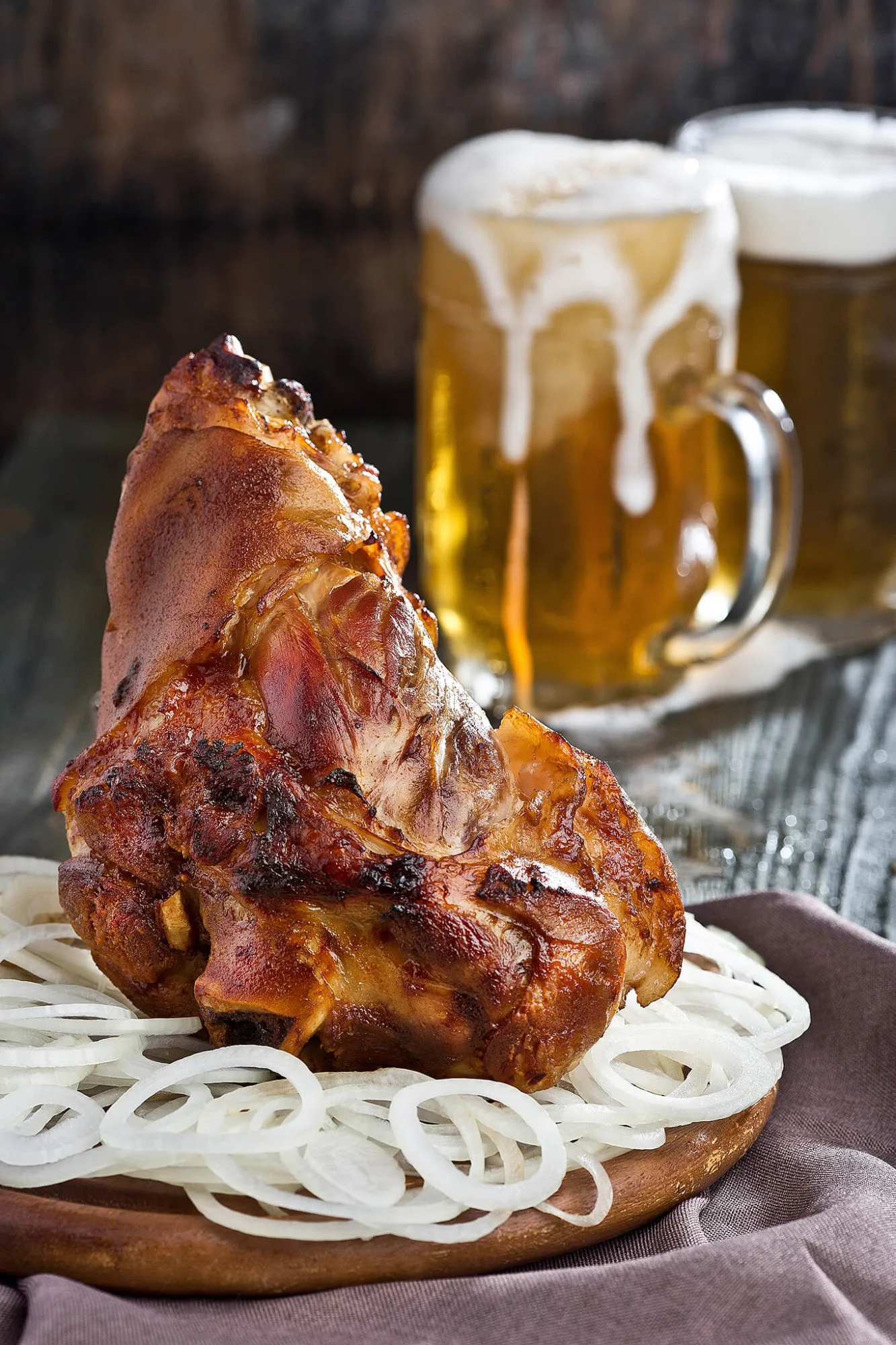 Roasted pork knuckle with onions and beer, food photo by Alex Slyadnev